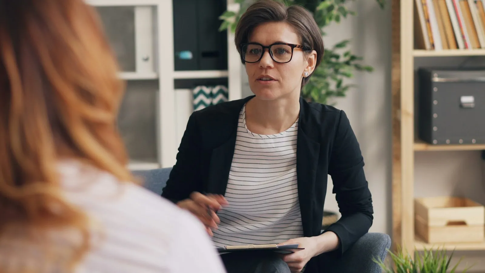 Psicóloga conversando com uma paciente em um consultório aconchegante