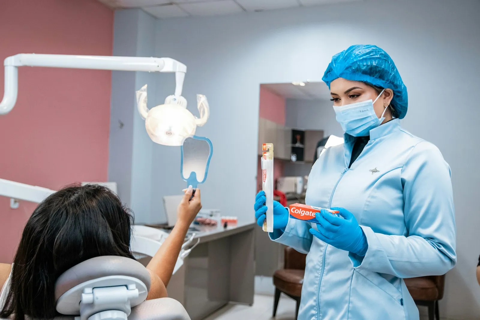 Dentista mostrando a escova correta para uma paciente no consultório
