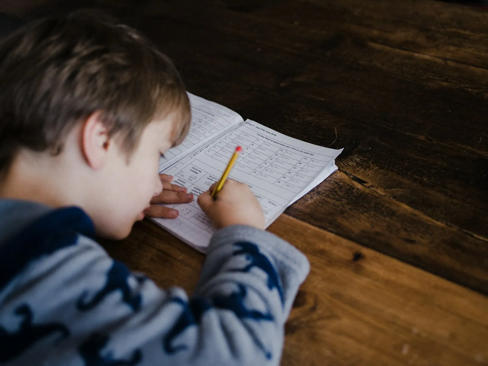 Aluno resolvendo exercícios no caderno